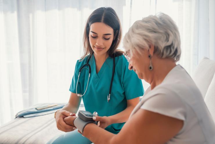 Nurse assisting patient with a device