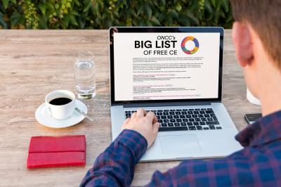 Person accessing Big List of Free CE on laptop