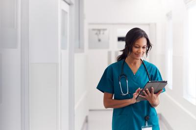 female nurse standing looking at tablet