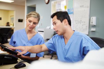 Two nurse colleagues looking at a computer screen