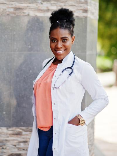 Nurse standing in labcoat outside