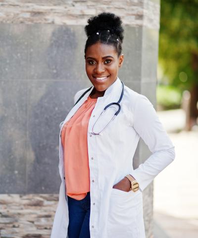 Nurse standing in labcoat outside